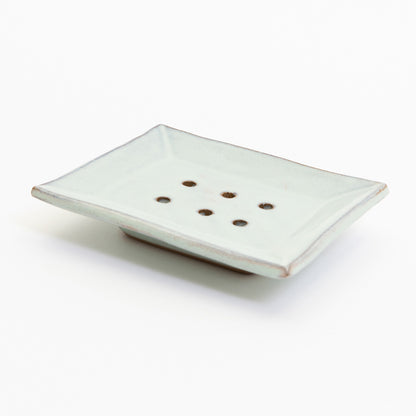 A stoneware soap dish in ice blue colour. Pictured on a white background.