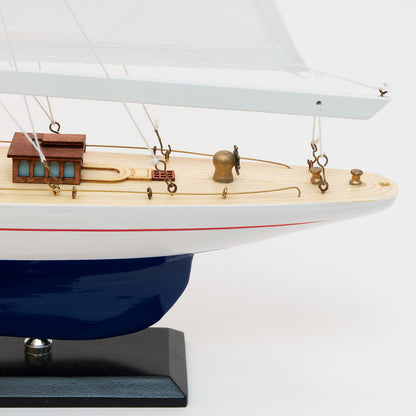 View of the Model J Class Yacht's stern with white sails and a blue and white hull.