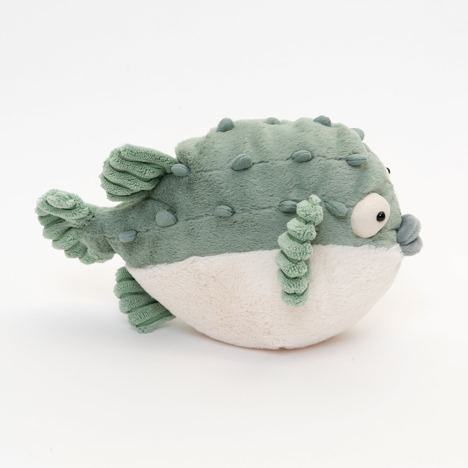 side shot of soft toy puffer fish in light green and white