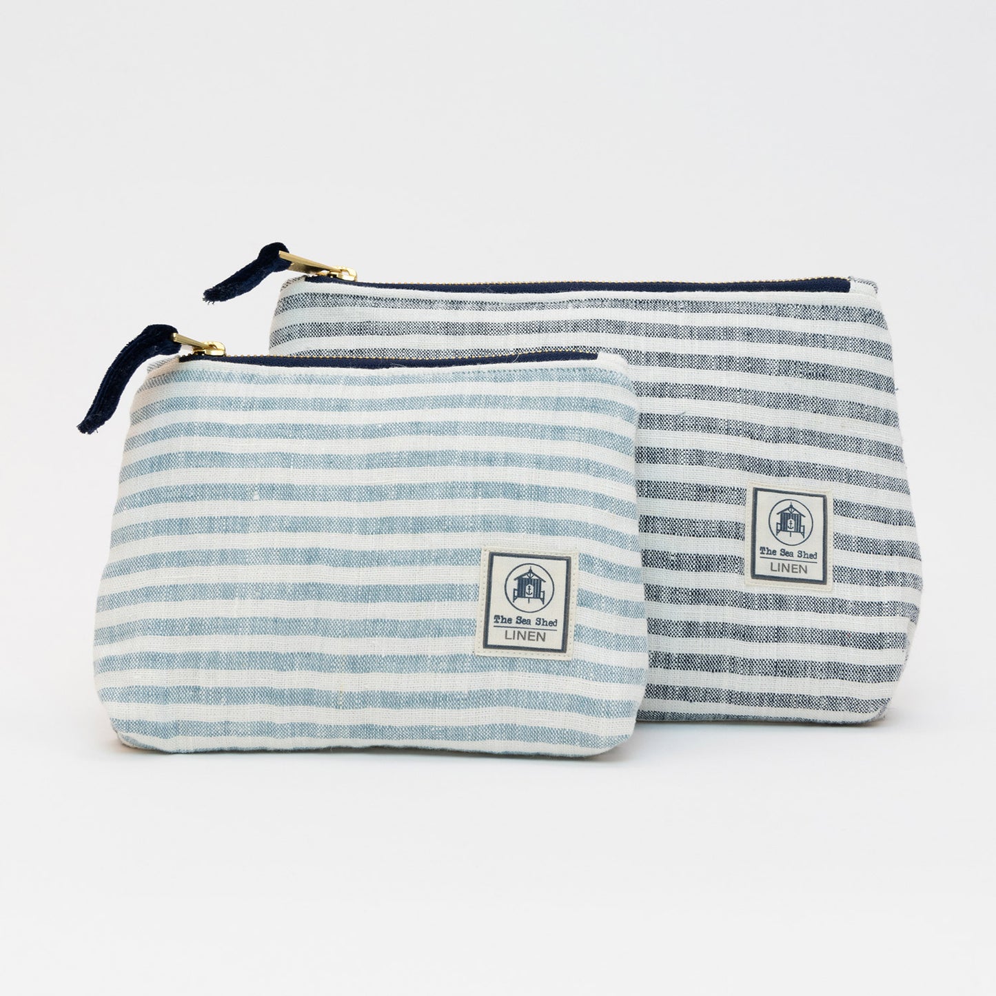 A photo of the large and small linen cosmetic bags on a white background. They have white and blue stripes.