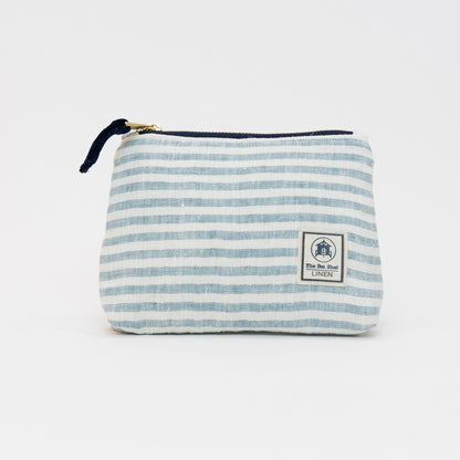 A photo of the small sea blue linen makeup bag on a white background. The bag has sea blue stripes and white stripes.