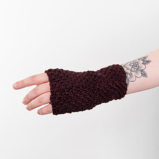 Shows a woman's hand wearing a purple wrist warmer