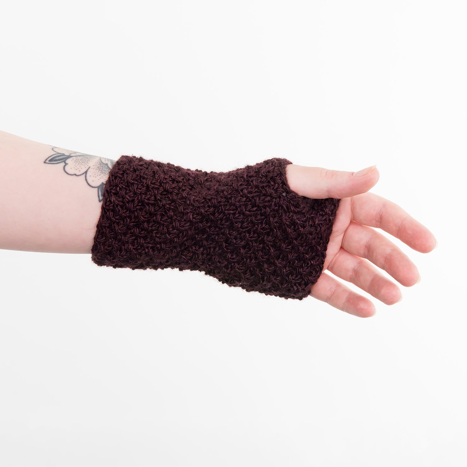 Shows a woman's hand wearing a purple wrist warmer