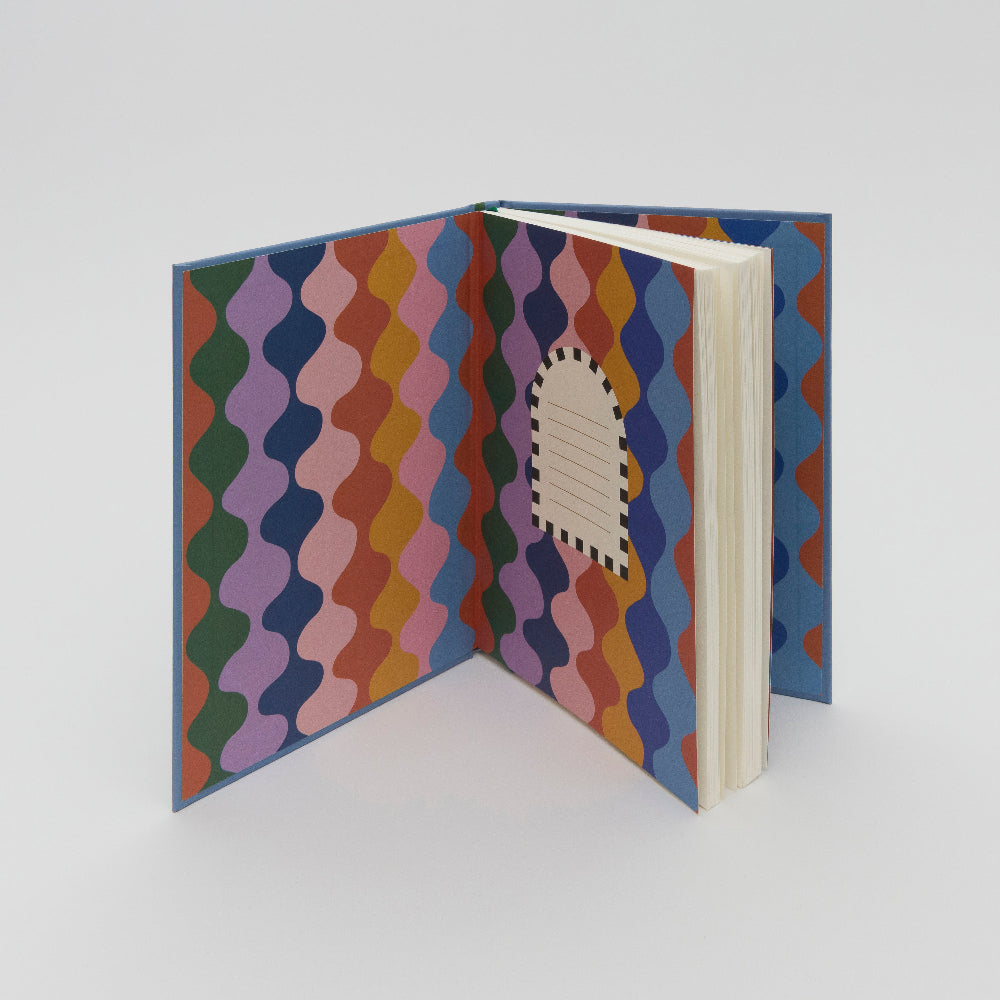 Inside front cover of lined journal showing groovy wiggly pattern in rainbow colours.  