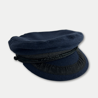 Navy blue hat with braided band on a light gray background
