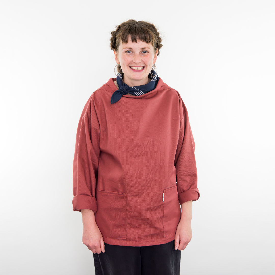 Person wearing a red smock with a white background