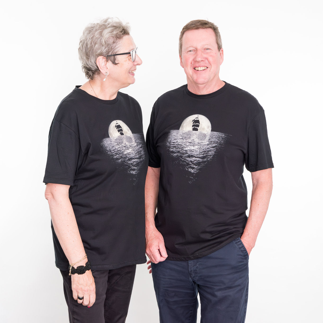 A woman and a man standing side by side wearing the Pirate Exhibition t shirt.