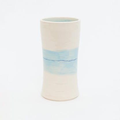 Ceramic vase with a gradient design from white to blue on a white background.