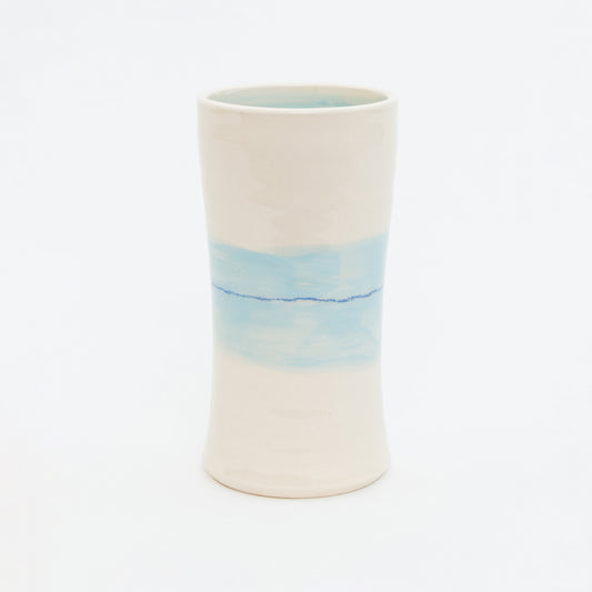 Ceramic vase with a gradient design from white to blue on a white background.