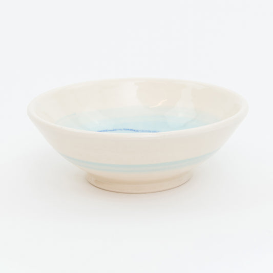 Ceramic bowl with light blue stripes on a white background