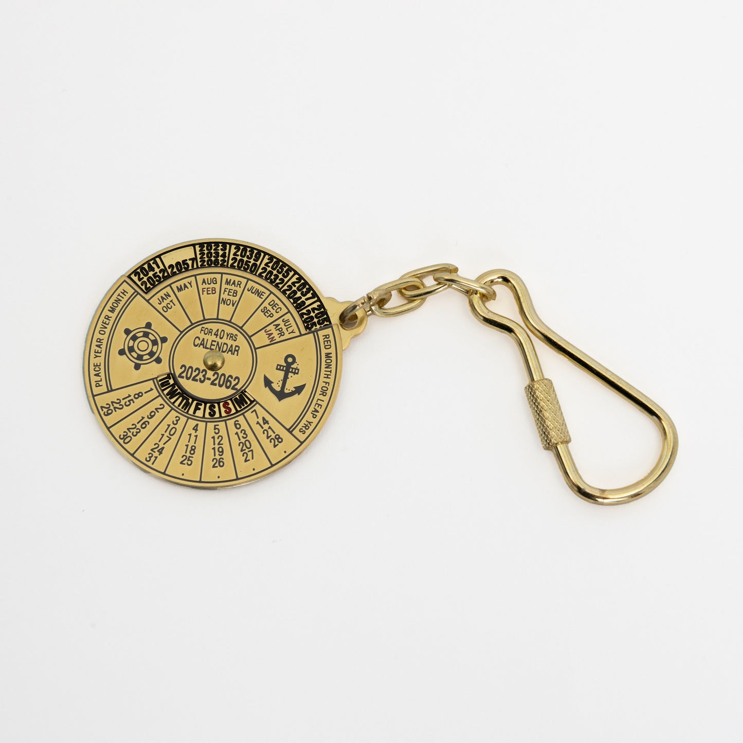 Brass circular keyring showing dates and an anchor and ships wheel