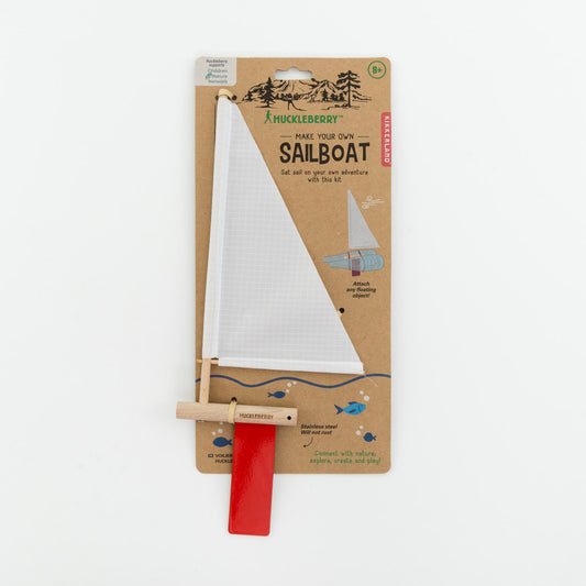 White sail and red rudder attached to a backing card