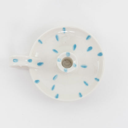 white with blue dabs ceramic candle holder with finger loop from above.