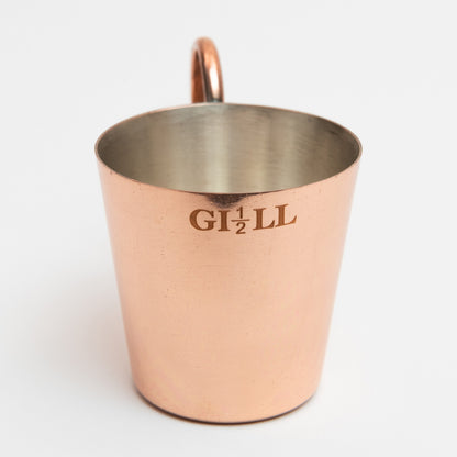 A copper-plated naval rum measure, cup with handle. Pictured on a white background.