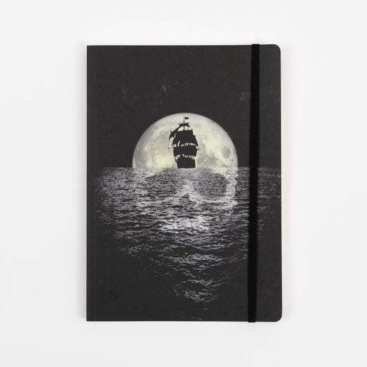 The black cover of the pirates journal with a illustration of a sailing ship in front of a moon and a skull reflection in the sea.