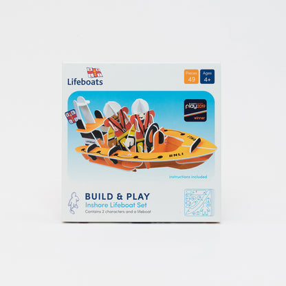 RNLI Inshore Lifeboat Playset. Press, Build & Play set in compact cardboard box. Two playboard RNLI team members in their yellow waterprroofs and life vests. Inside their fully buildable playboard RNLI dingy boat.