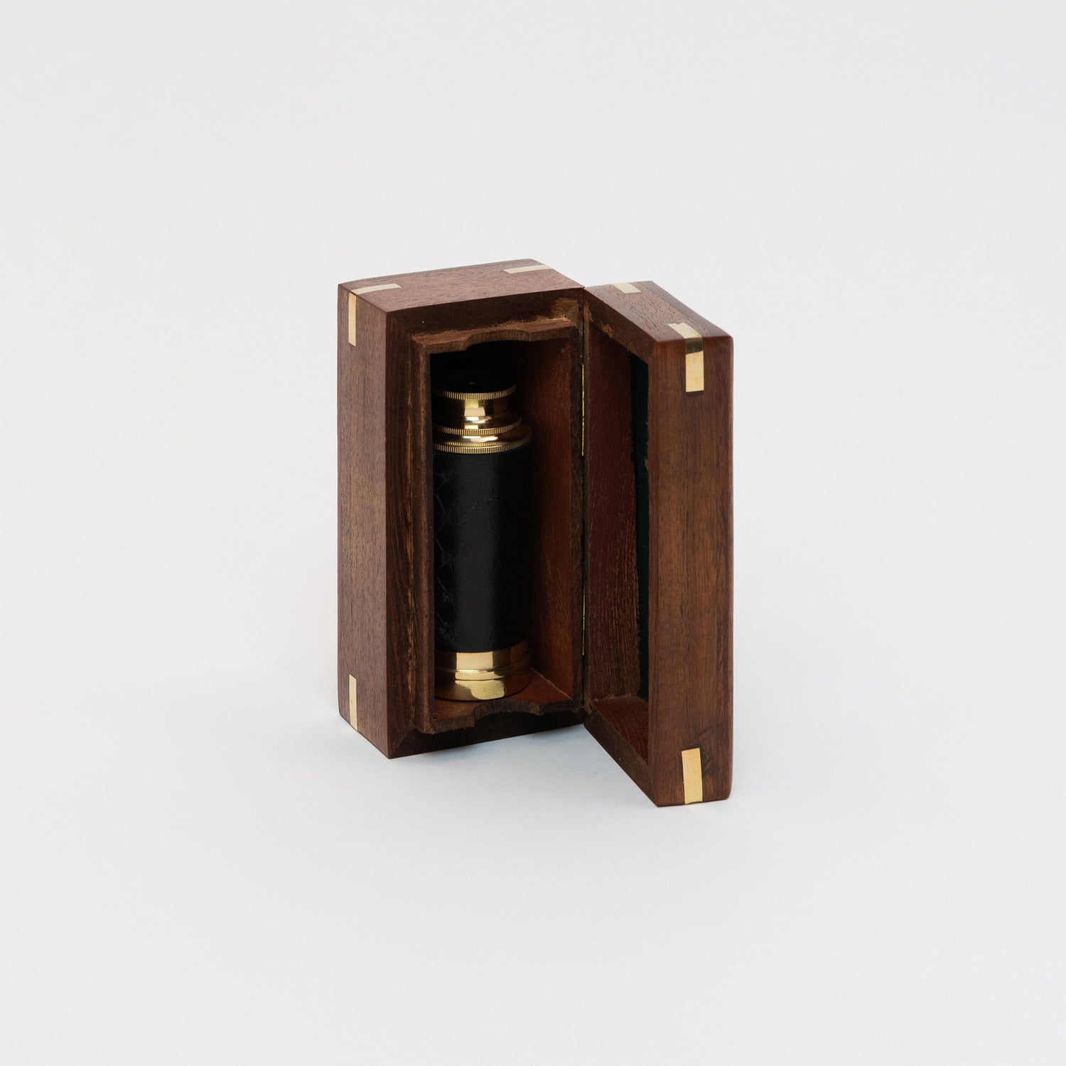 A photo of a brass pocket telescope inside a wooden box. Pictured on a white background.