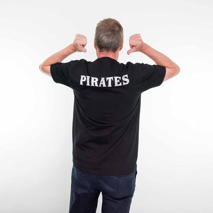 Man wearing the Pirates Exhibition T-Shirt pointing to the design on the back.