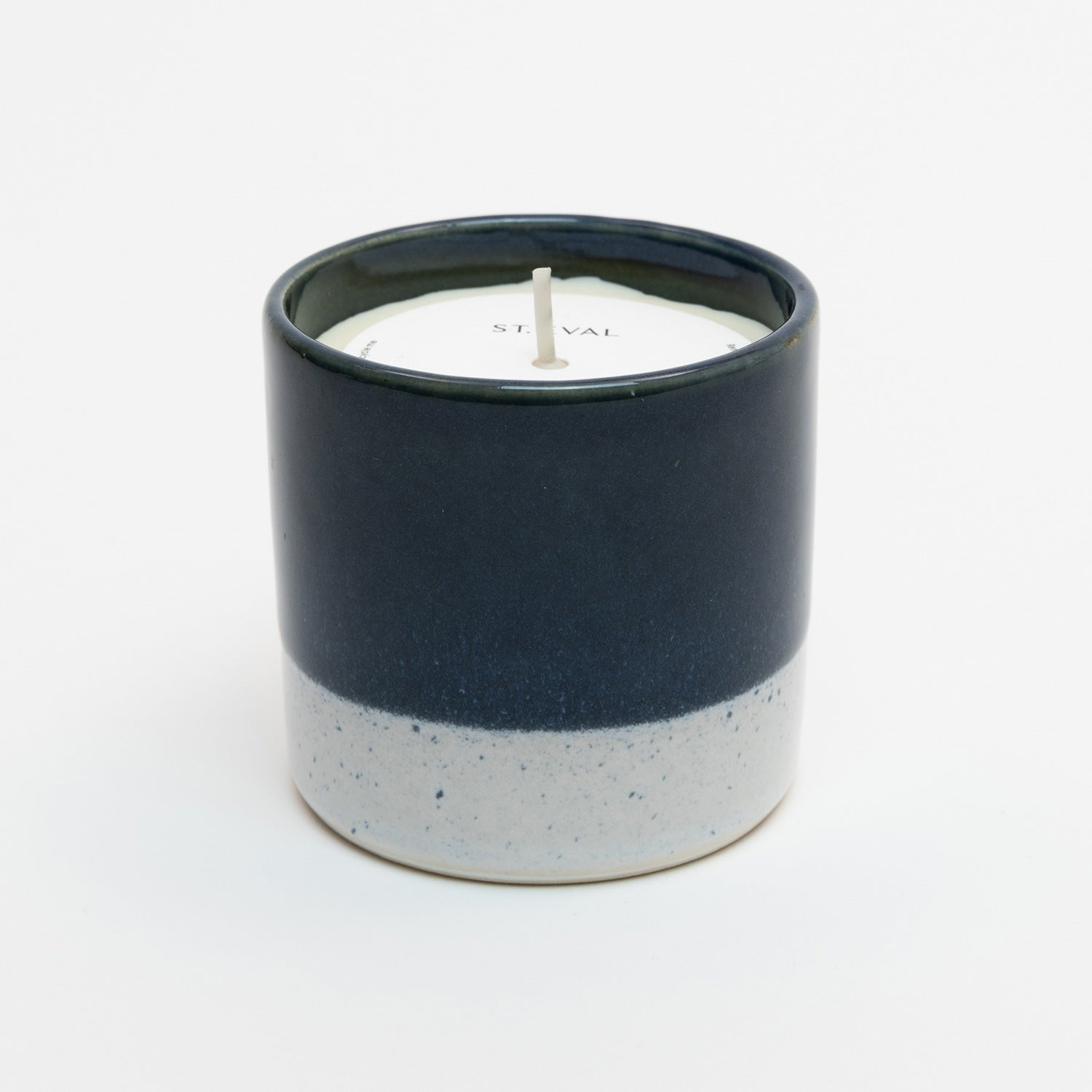 St Eval Sea & Shore Salt candle pot. Stoneware ceramic pot. Navy blue top with grey ring at base. St Eval card circle protector on top of candle with wick standing tall.