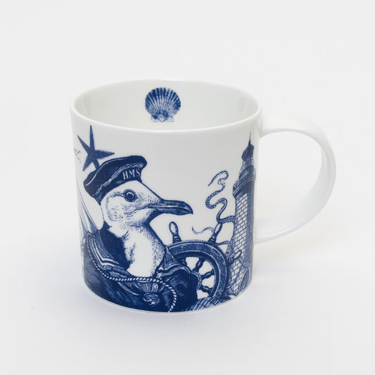Shot of white mug with blue illustration of a seagull wearing a captains cap. a  blue shell is printed on the inside of the mug
