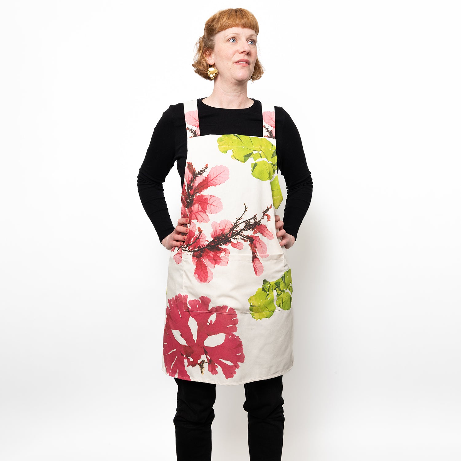 Model wearing white apron with large seaweed pressings in pink and green