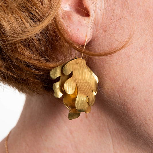 close up of brass seaweed wave earrings
