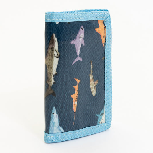 A blue children's wallet with shark illustrations on it. Pictured on a white background.