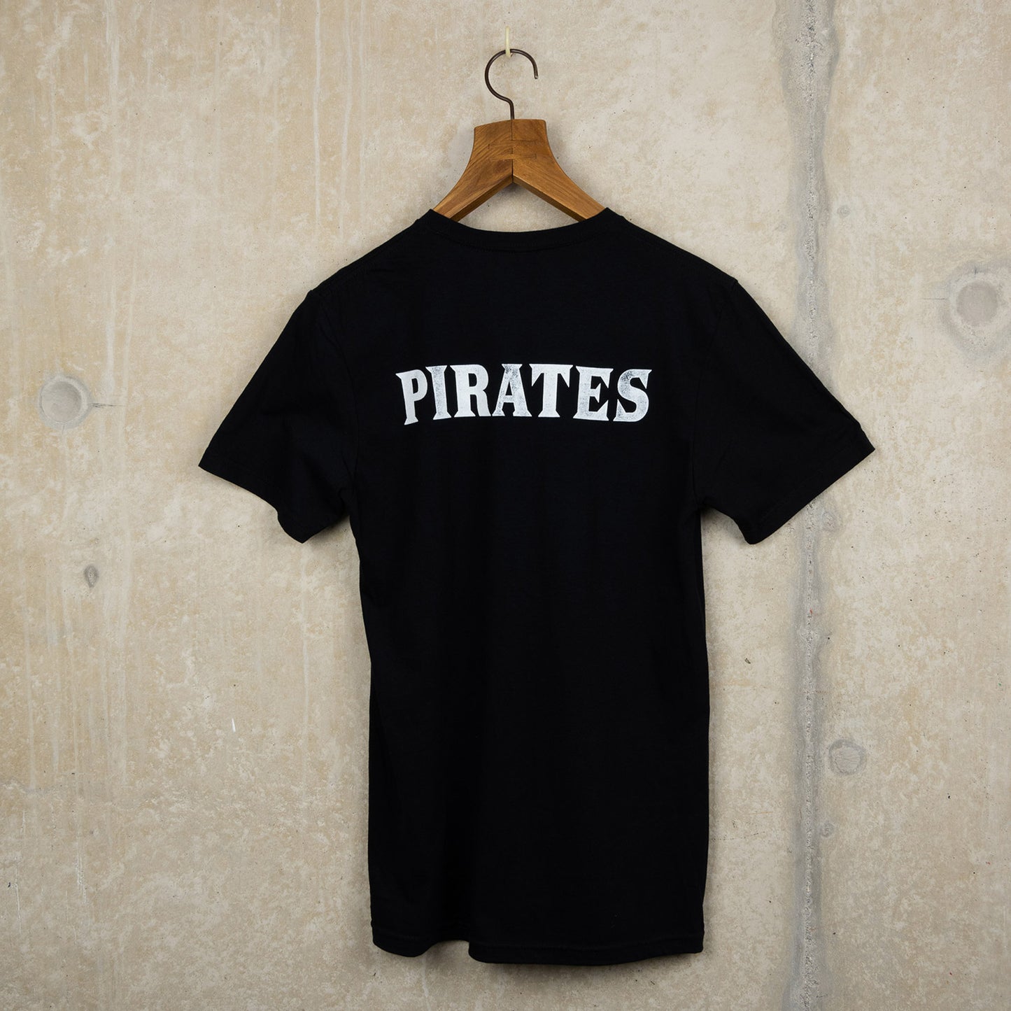 Black t-shirt with pirate exhibition artwork on the front and the word Pirates on the back