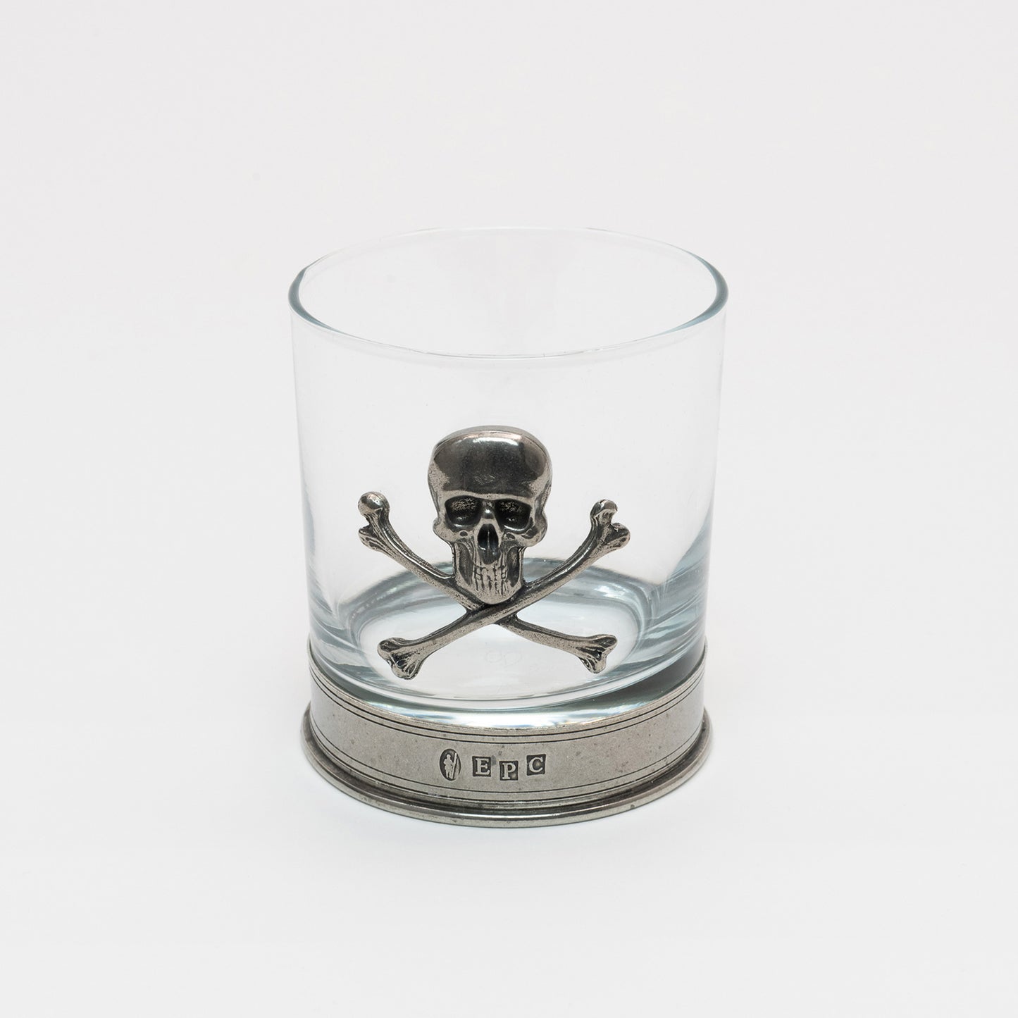 Clear glass with a pewter base and pewter skull and cross bones on the side of the tumbler.