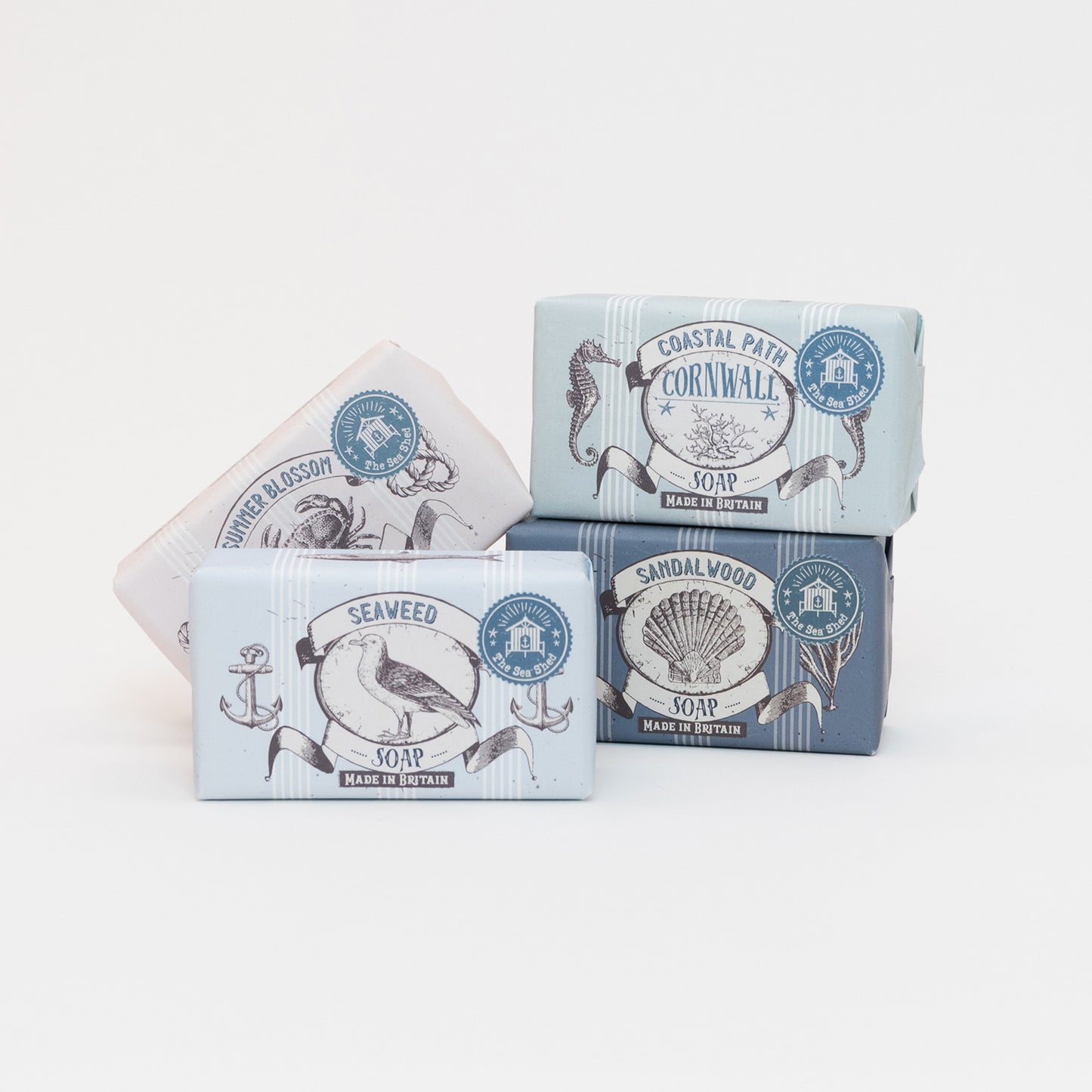 Four variants of Cornish soap stacked on top of each other on a white background: Seaweed, Sandalwood, Coastal Path, and Summer Blossom.