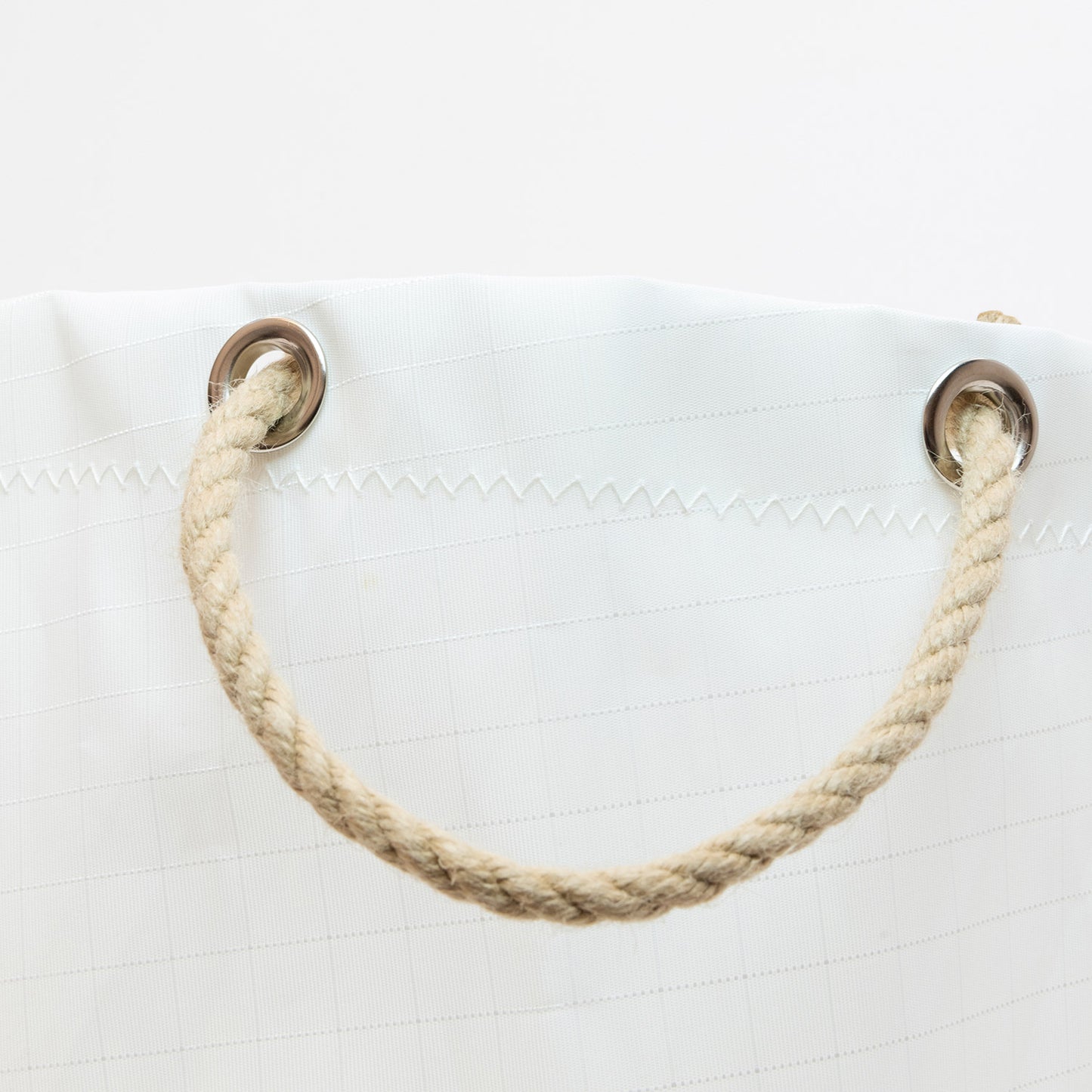 Round bucket bag in white close up of Rope handles.