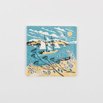 A top down view of the Falmouth Tall Ships Coaster in a yellow, blue and white design featuring a tall ship in full sail.