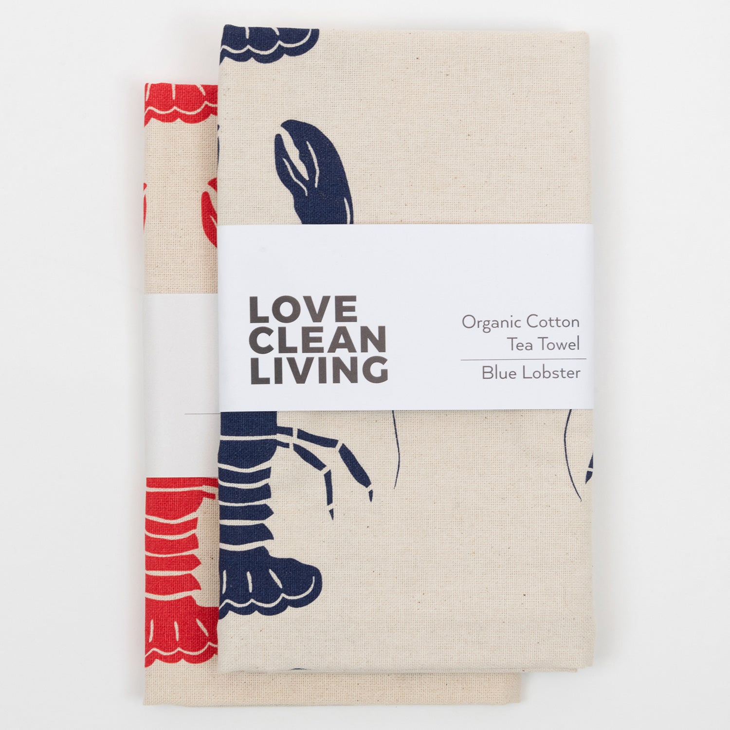 The Navy Lobster Tea Towel and the Red Lobster Tea Towel in a pile and in packaging.