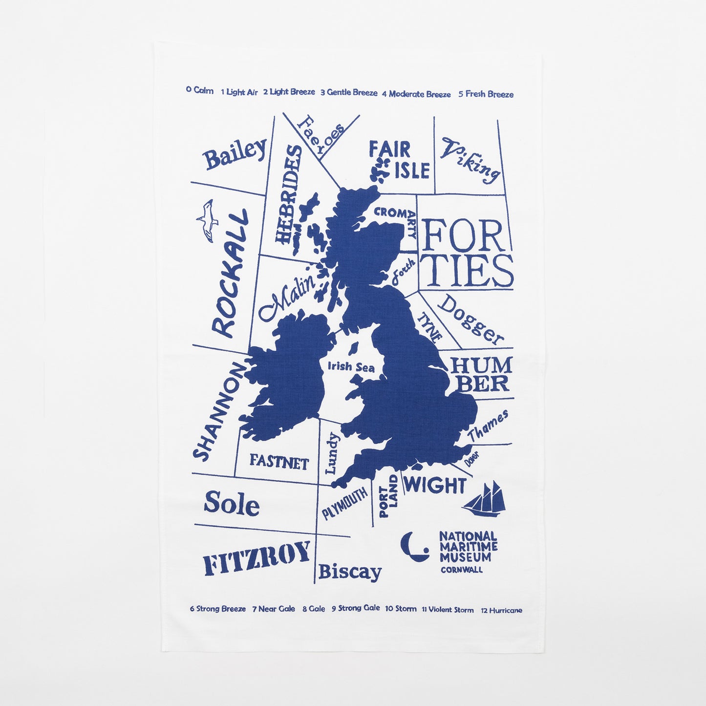 Blue and white shipping forecast tea towel on a grey background.