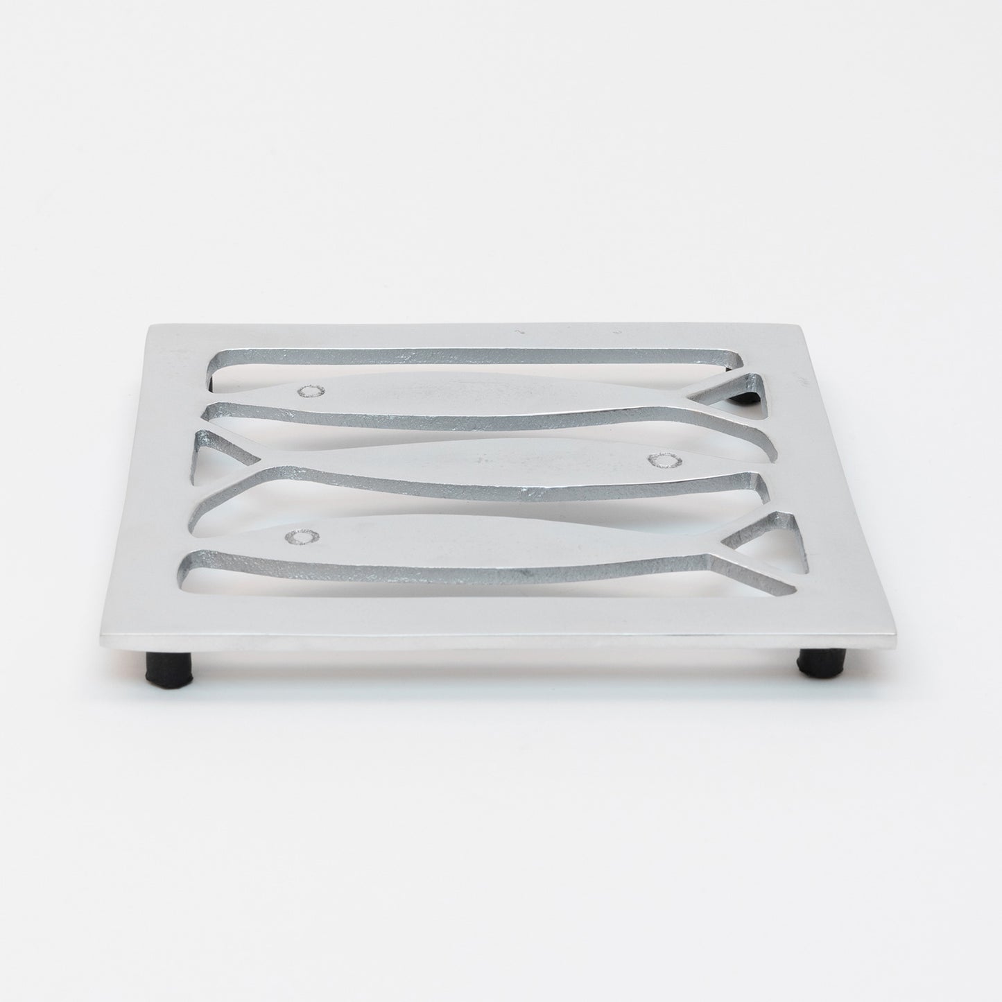 Top view of the stainless steel square trivet with fish cut outs and black rubber feet,