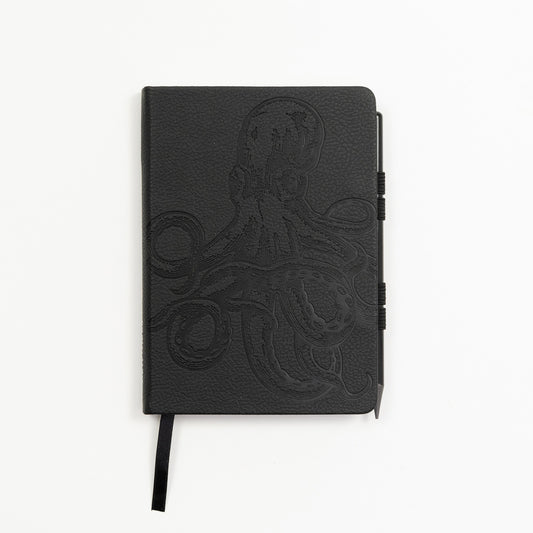 A black notebook with an octopus etching on the front cover. Pictured on a white background.