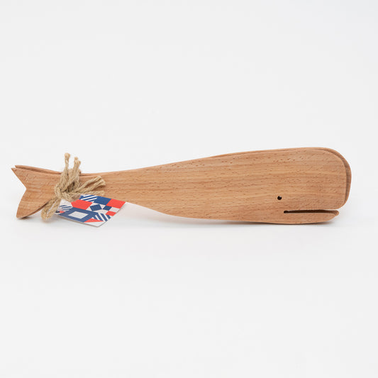 Side view of the wooden salad servers shaped like a whale. There is brown string securing the servers together with a label.