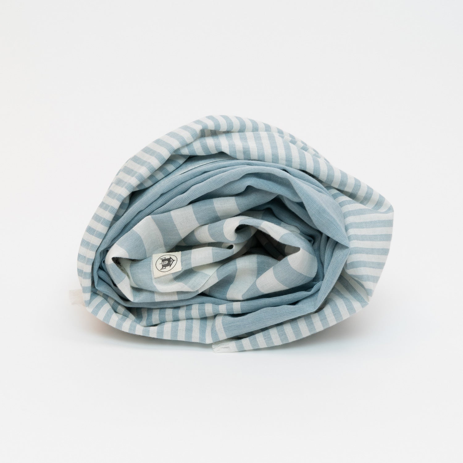 A photo of the sea blue scarf rolled up on a white background.