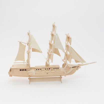 A wooden sailing ship construction kit. Pictured on a white background.